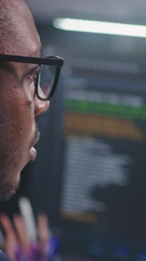 African American Software Engineer Looks at Computer Screen