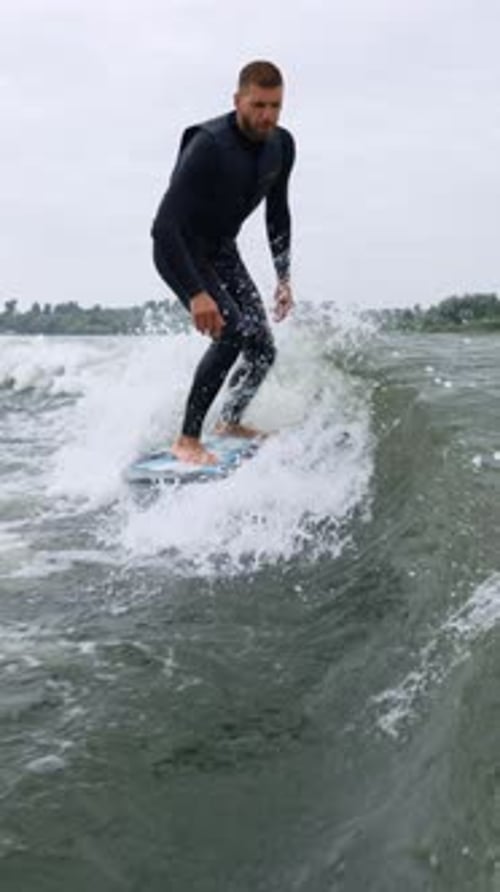 A Skilled Surfer Masterfully Riding a Wave Showcasing Balance and Agility on the Water Amidst Choppy