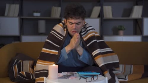 Man Wrapped in Blanket Counting Money