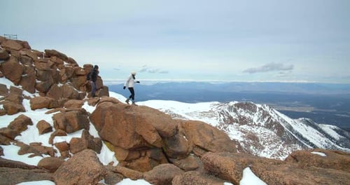 Couple on Rocks High Above Rocky Mountains, Dangerous Hike Adventure