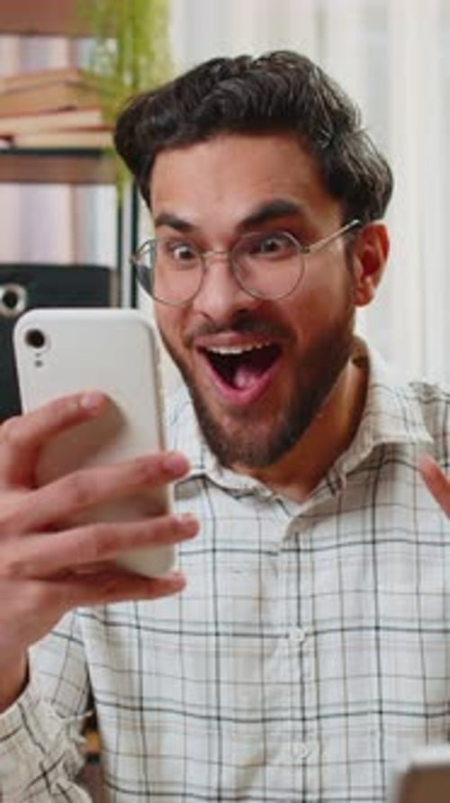 Excited Young Man Receives Good News on Phone
