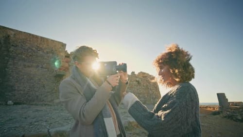 Couple Filming with Vintage Camera at Historic Site