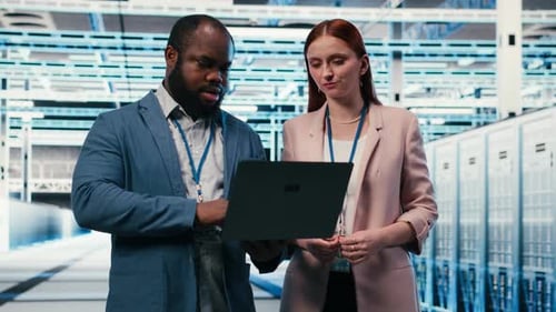 Engineering Team in Server Hub Working Together with Laptop to Do Maintenance