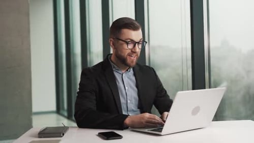 Man Working at Laptop During Video Conference