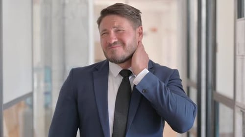 Man in Suit Massages Sore Neck