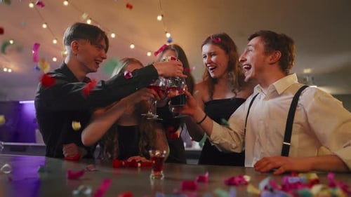Friends Celebrating with Drinks and Confetti at Party