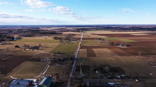 Majestätische Kleinstadt und Ackerland am Horizont in einer Drohnenaufnahme aus der Luft