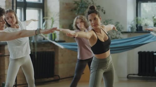 Women Practicing Triangle Pose on Yoga Class