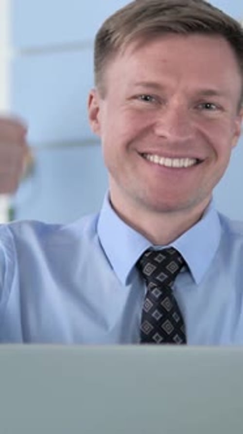 Smiling Man in Office Gives a Thumbs Up