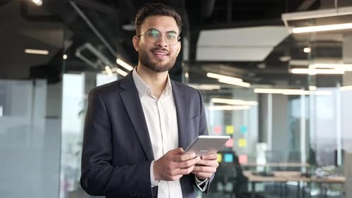 Smiling Man Using Tablet in Modern Office