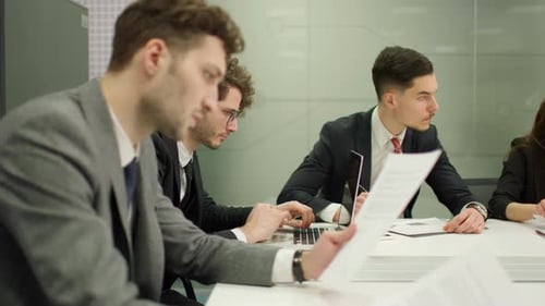 Team of Professionals Analyzing Paperwork in Office Setting