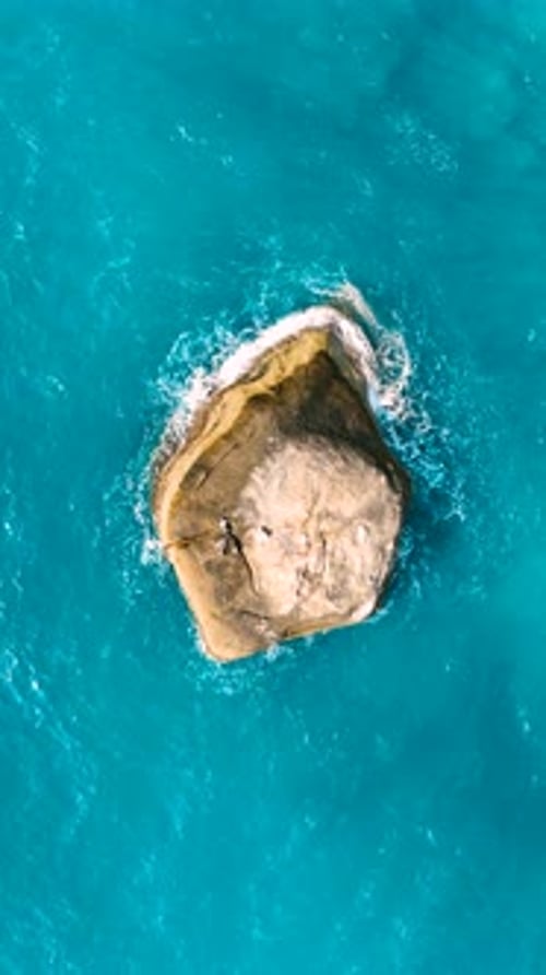 Stunning aerial view of a solitary rock. Vertical video