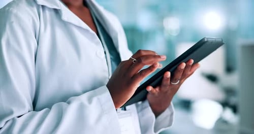 Doctor Using Tablet in Brightly Lit Lab
