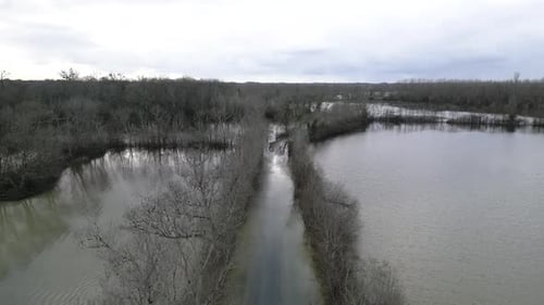 Aerial view of flooded road surrounded by trees, France.