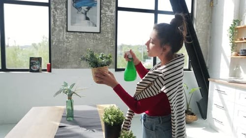 Woman Waters Plants in Bright Apartment