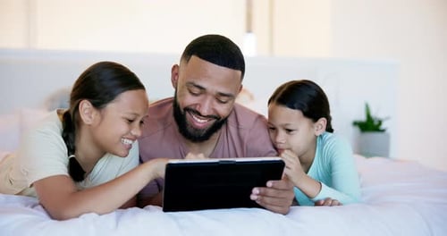 Father and Daughters Enjoying Tablet in Bedroom