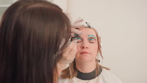 Woman Receiving Expert Eyebrow Tinting Close View of Professional Eyebrow Coloring Process Upclose