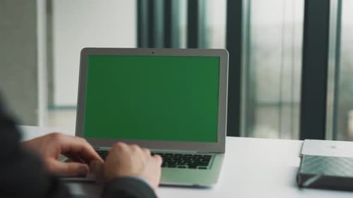 Male hands flipping the touchpad of a laptop with a chroma key on the screen