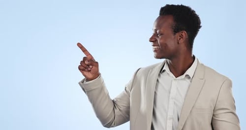 Happy black man, pointing and steps in advertising or marketing against a blue studio background