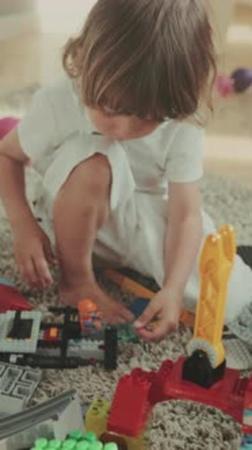 Young Child Stacking Vibrant Blocks on Floor Boy Meticulously Arranging Bright Blocks in Sunlit Play