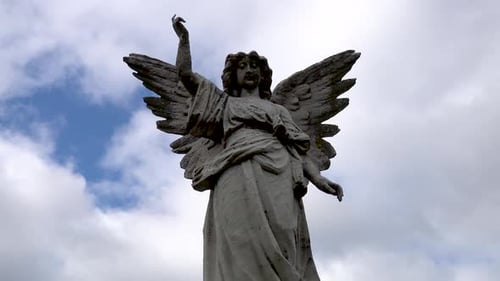 Weathered Stone Angel Statue Under Cloudy Sky