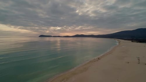 Aerial View of Beach with Calm Transparent Sea Water and Sky Reflection at Sunset Camera Moves