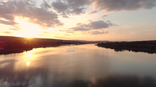The Sun is Casting a Golden Glow As It Sets Over the Tranquil Lake