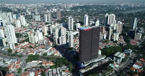 Backward motion shot with Drone moving away from a beautiful glass building in the city of São Paulo