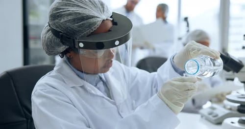 Woman Scientist in Lab Coat Pouring Liquid
