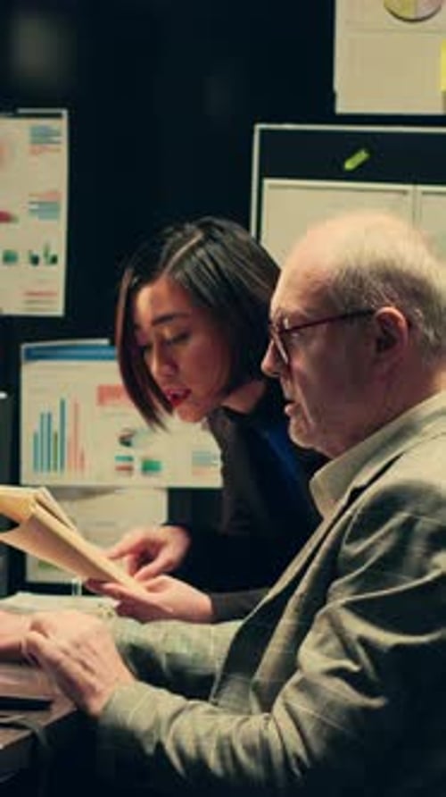 Two Colleagues Collaborating in Modern Office at Night