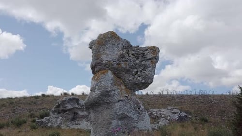 Felsvorsprung in einem Naturgebiet, der sich mit Wolken vom Himmel abhebt, Bogenaufnahme