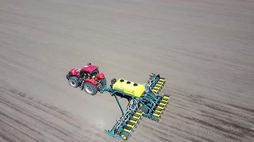 Tractor with yellow seeder working on the field in Ukraine OA Lexa
