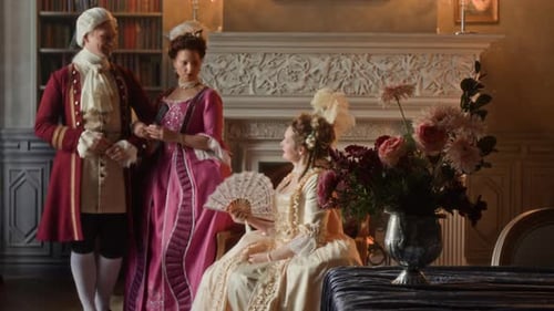 People in period clothing in ornate historical room
