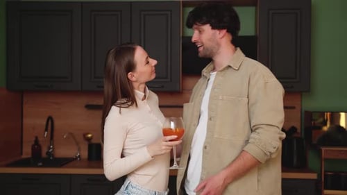 Young Couple Talking and Smiling in Kitchen