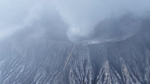 aerial view flying to mount Bromo active volcano above sea of clouds, Java, Indonesia