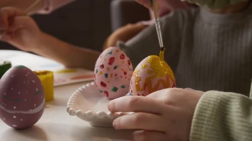 Kreative kleine Mädchen malen Eier für die Osterfeier