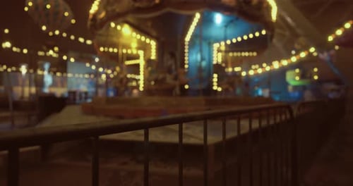 Nighttime Carnival Atmosphere with Vibrant Lights and a Carousel in View