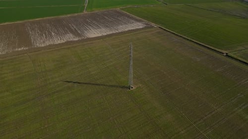 Aerial View of Power Line Tower in Green Field