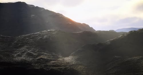 Sunlight Breaks Over Rugged Mountain Terrain in a Breathtaking Landscape