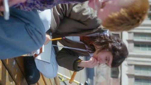 College Friends Writing in Copybooks and Speaking Outdoors on Campus