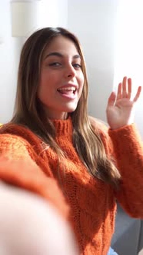 Woman Smiling and Waving at the Camera