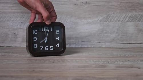 Male Hand Puts an Arrow Mechanical Watch on a Wooden Table