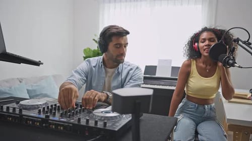 Diverse young stylish audio producer working in the music record studio.