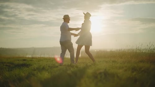 Couple Dancing on Sunlit Grassy Hill at Sunset
