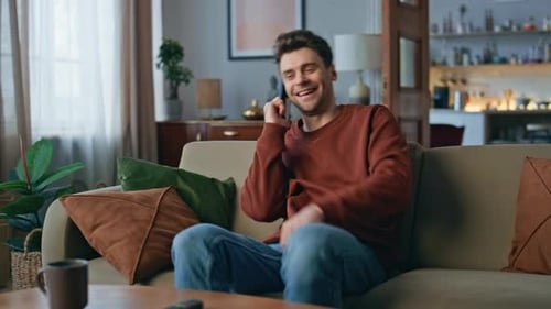 Man Talking on Smartphone on Couch at Home