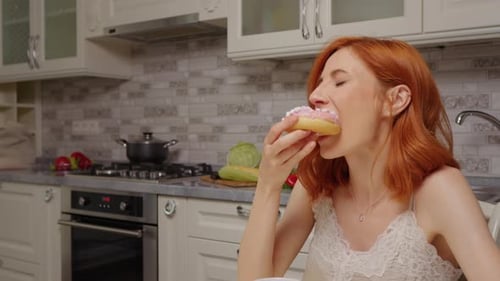 Smiling Woman Enjoys Doughnut Treat with Friend at Home
