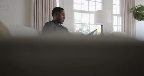 Man Relaxing on Sofa Using Tablet Device