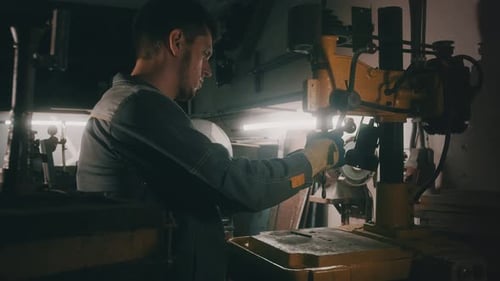 Ein Arbeiter arbeitet in einer Werkstatt an einer Metallbohrmaschine