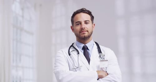 4k video of a young male doctor standing in a hospital