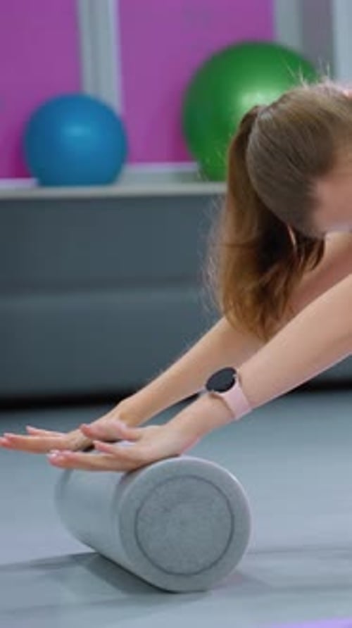 Flexibility Exercise with Foam Roller and Fitness Ball in Gym